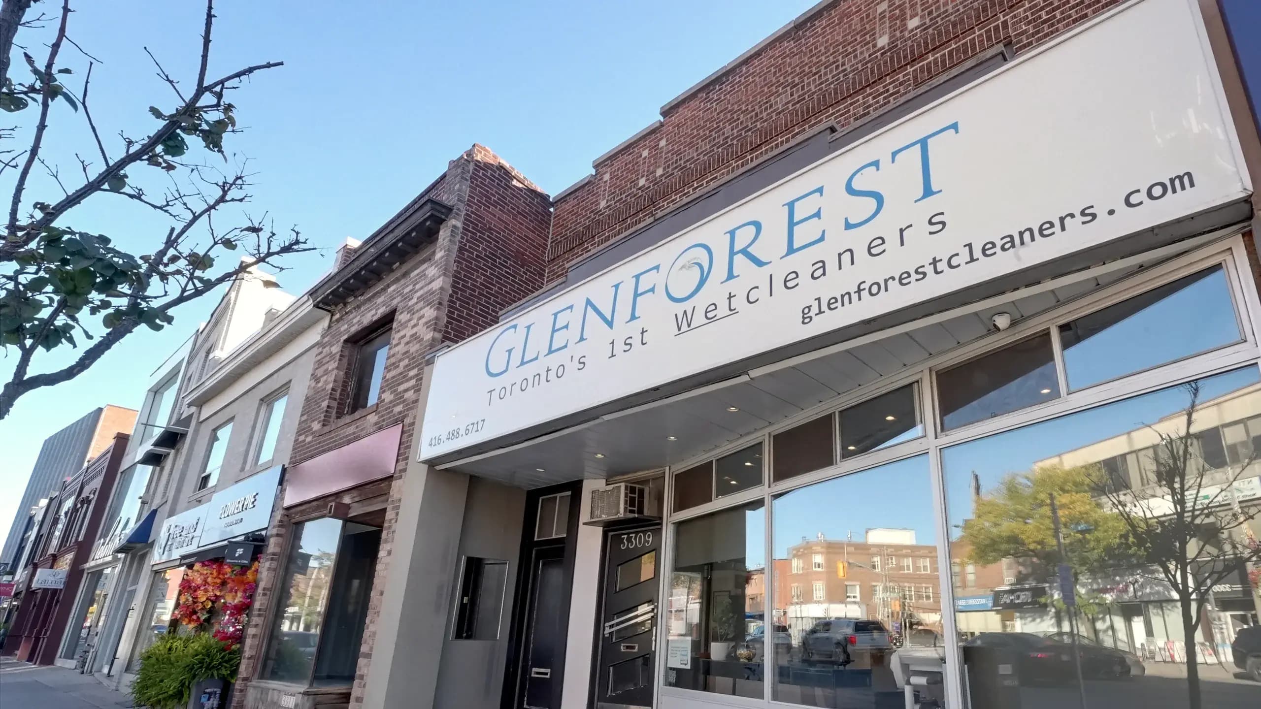 The Glenforest sign above the shop windows at 3309 Yonge Street, Toronto, seen from the sidewalk on a sunny day