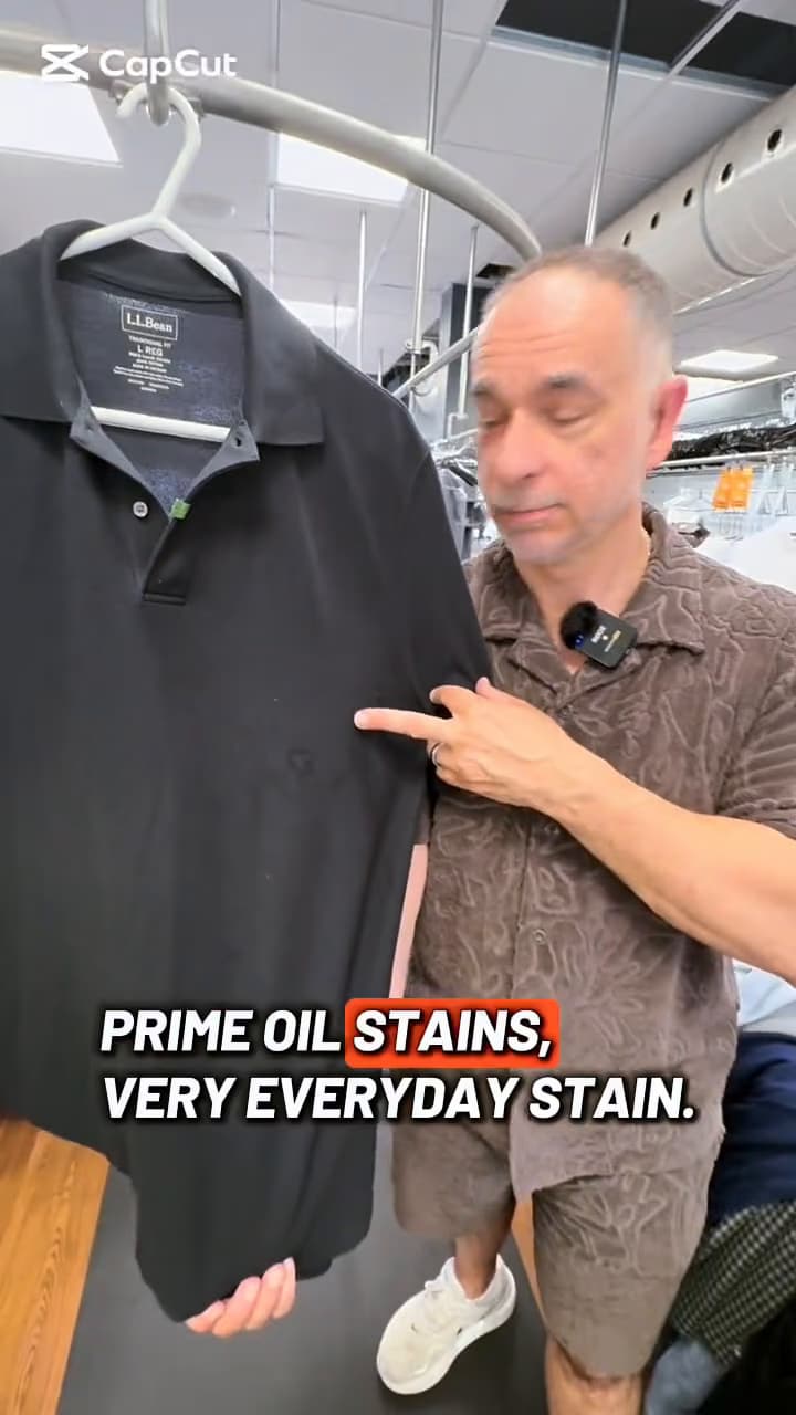 Alex showing an oil-stained dark polo shirt